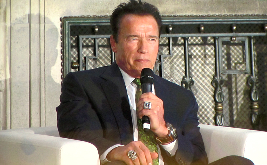 Arnold has the microphone. On his finger: a ring in the shape of a skull