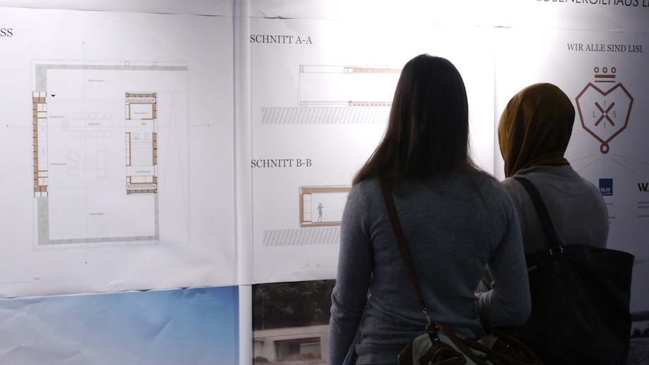 Two girls standing in front of LISI posters, studying the graphics.jpg