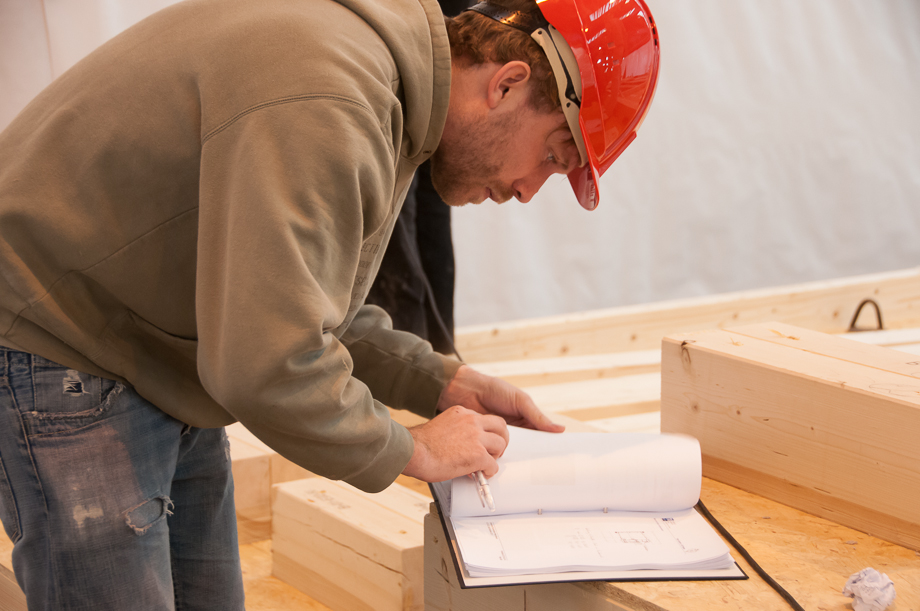 Claus wearing a helmet, checking some technical drawings