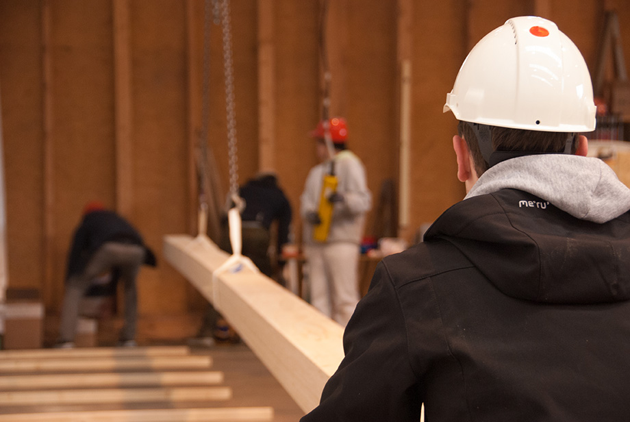 Sebastian stabilizing a beam being lifted by a crane