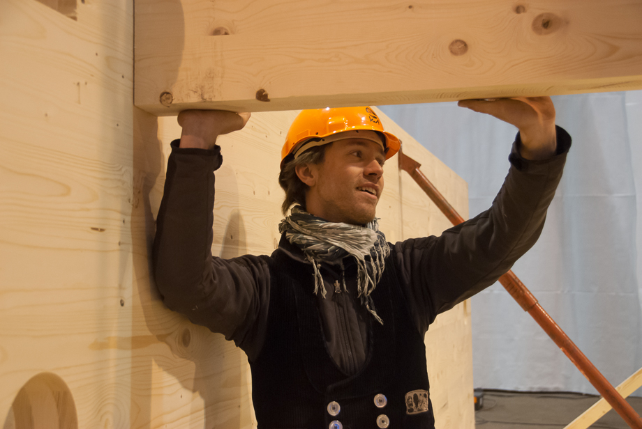 Dominik holding a giant beam. He's smiling a little