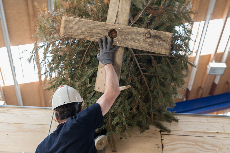 Lifting a tree onto the roof for a topping-out ceremony