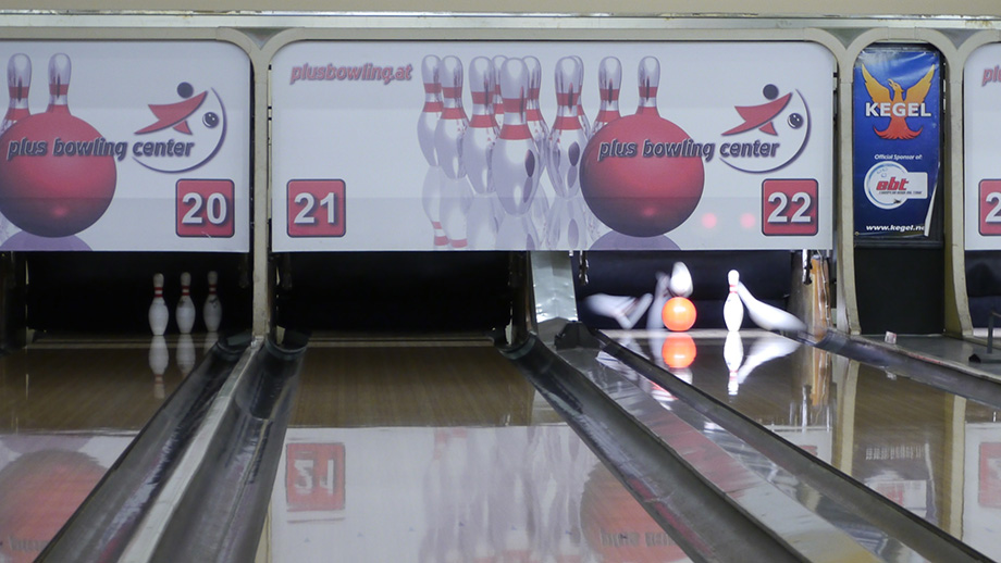 Someone cooling their hand over a fan. Bowling balls in the background