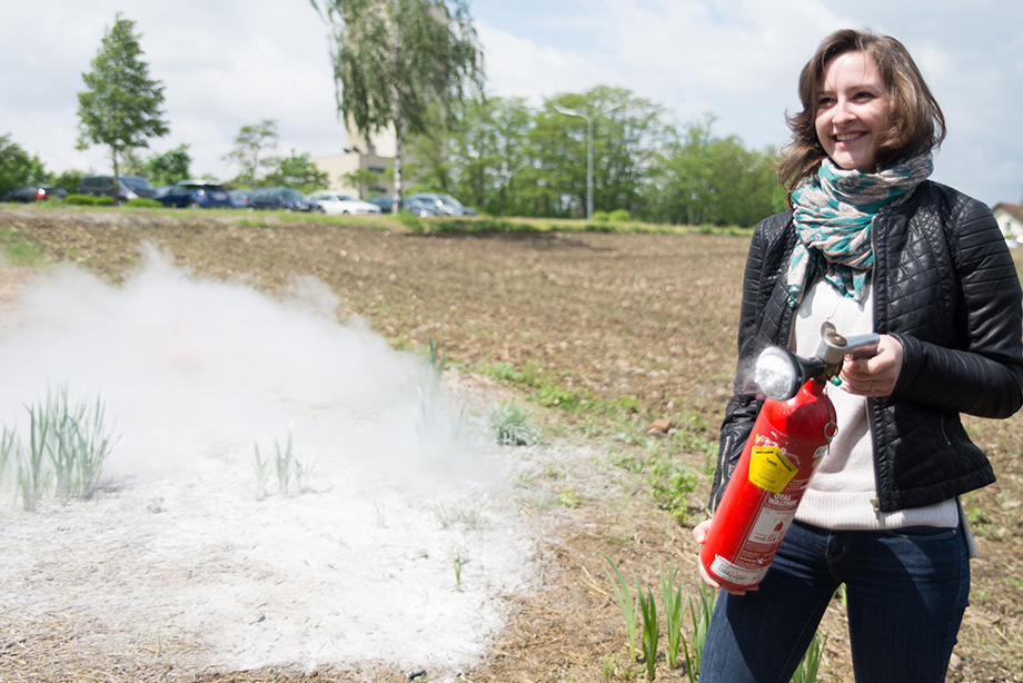 Kathi smiling with a fire extinguisher in her hand