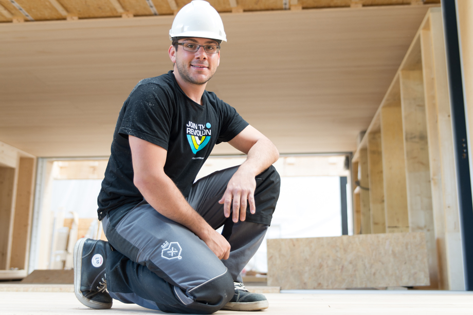 Rainer displaying his work pants with a LISI logo