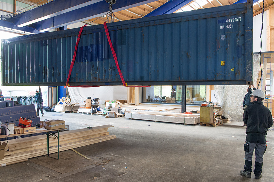 A huge container is being lifted through the hall