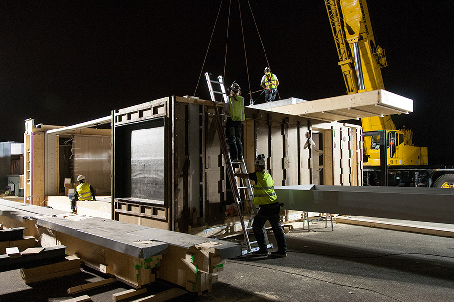 The first ceiling module is being lifted by the crane.