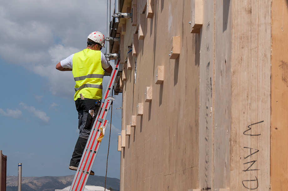 Side view of a ladder with someone on it.