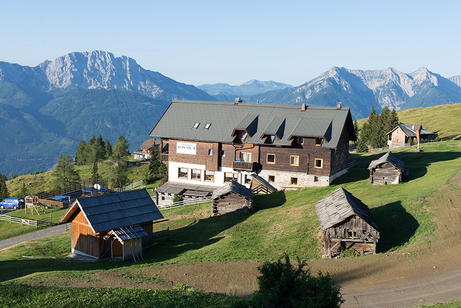 The house of the old man is situated on a mountain slope looking at a beautiful alpine landscape.