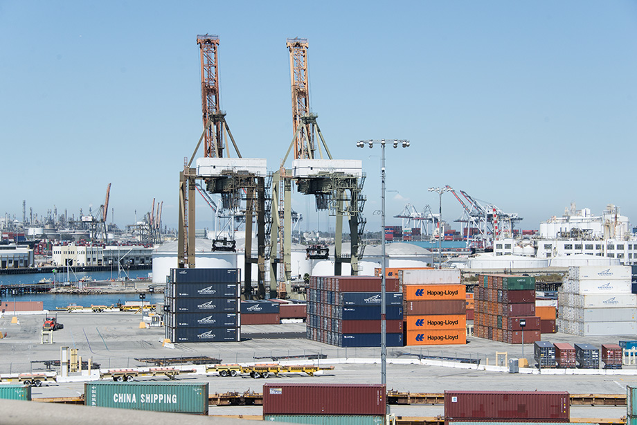 An overview of Los Angeles Harbor. Two cranes in the foreground.