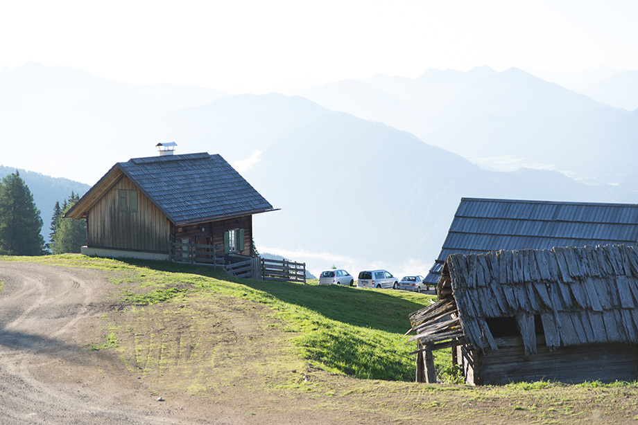 The two houses standing on a slope. In the distance, there are mountains.