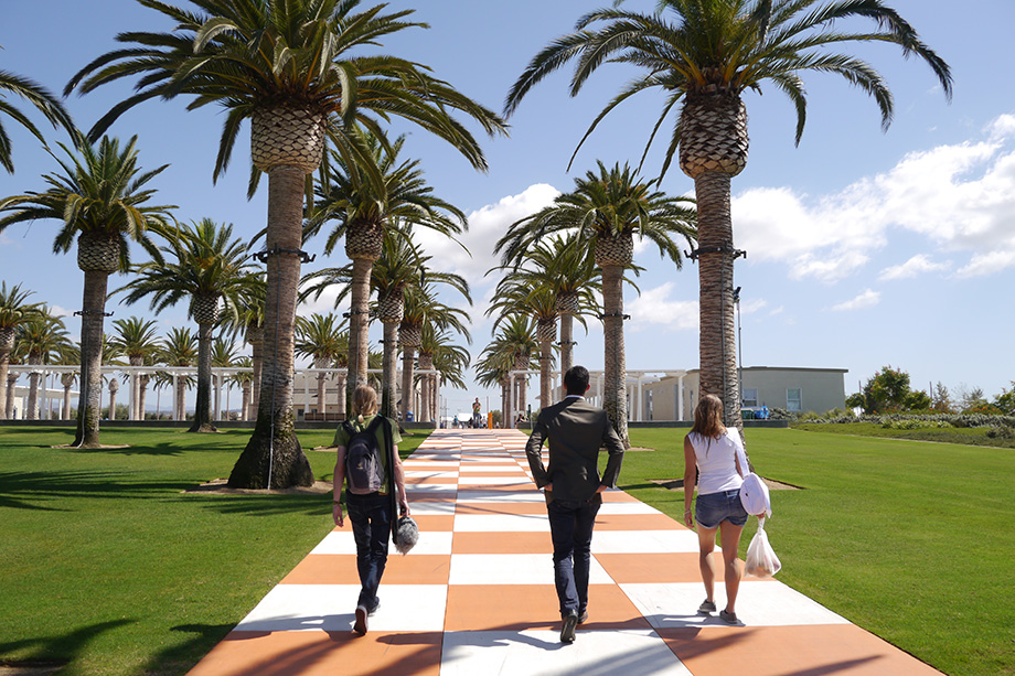 Adrian and Edith walking across a small plaza covered in palm trees.