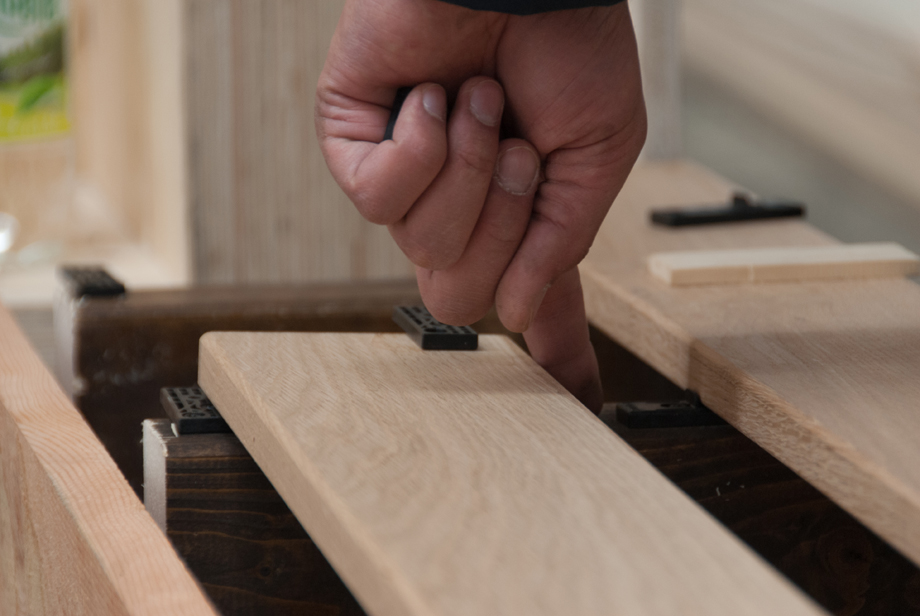 A closeup of a finger stroking wood finishing.