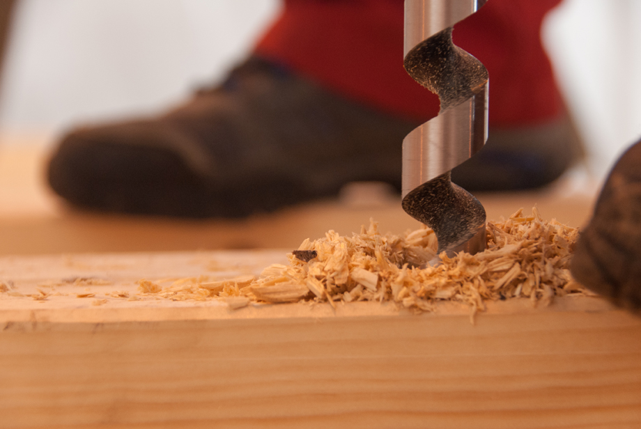 A drill going into a piece of construction wood.