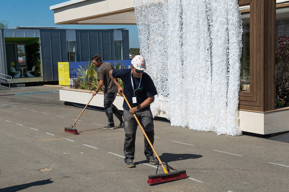 Two decathletes cleaning the construction site.