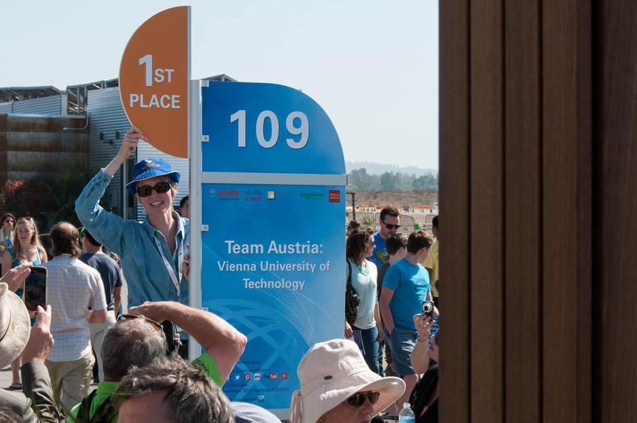 Team Austria receives the new "1st place" sign in front of their house.