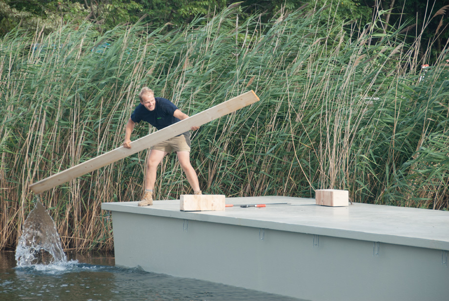 Decathlete Wolfgang is paddling on a pontoon. He is using a piece of wood.